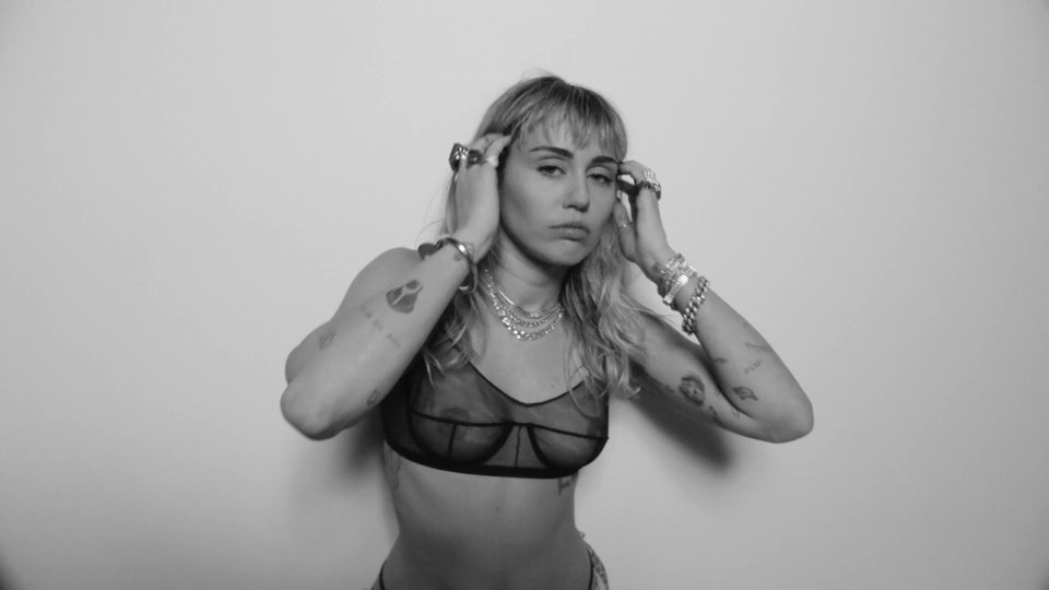  Miley Cyrus wears black sheer bra to promote latest track