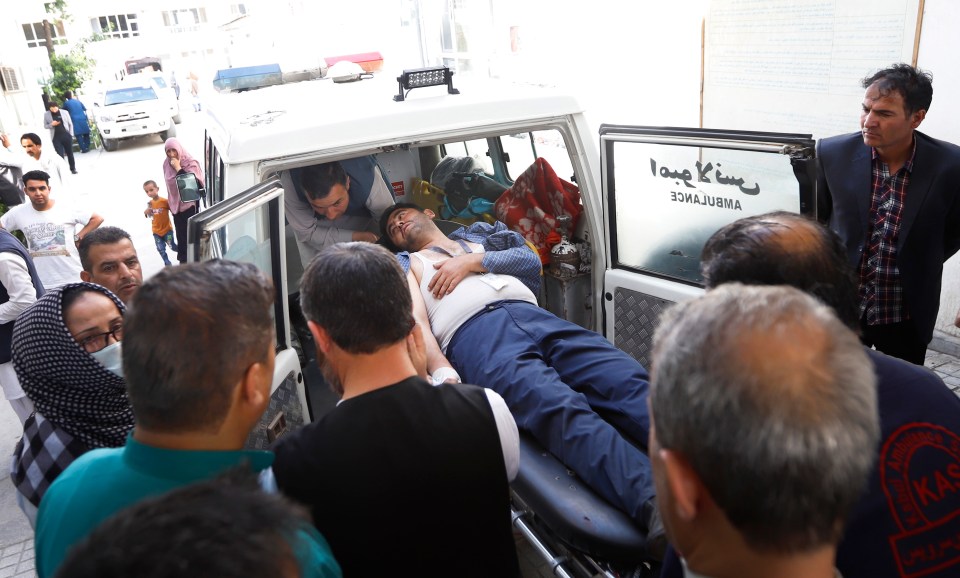  Kabul ambulance workers carry a wounded man after the explosion