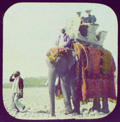  Two women ride an ornately decorated elephant