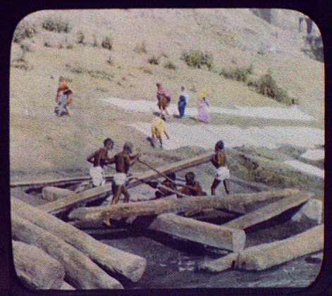  Workmen saw wood on the banks of the Ganges