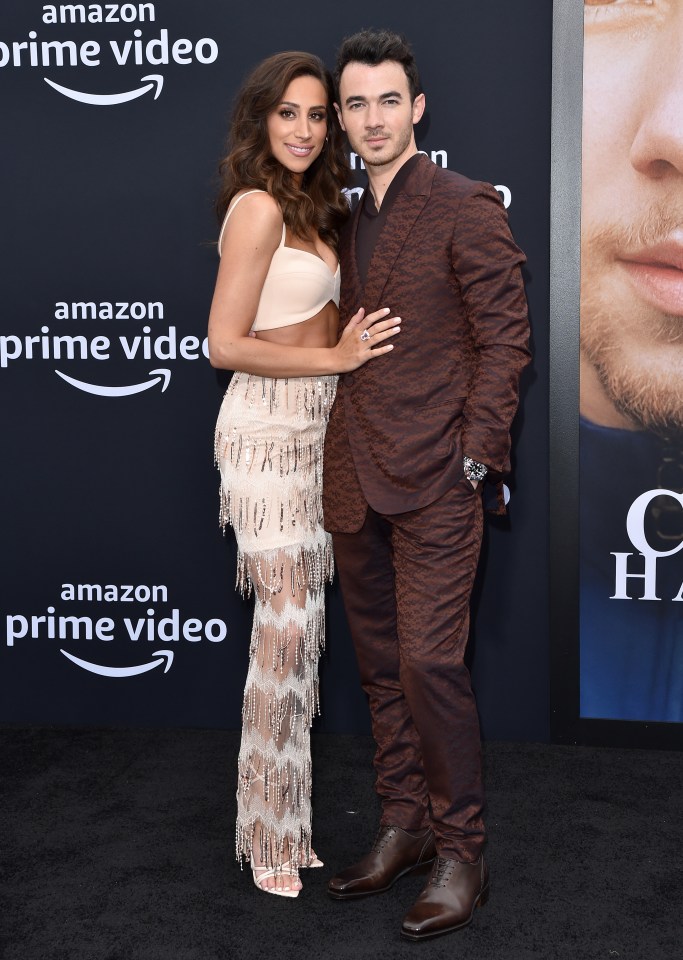  Kevin Jonas in a burgundy suit with wife Danielle in a ­tassled outfit