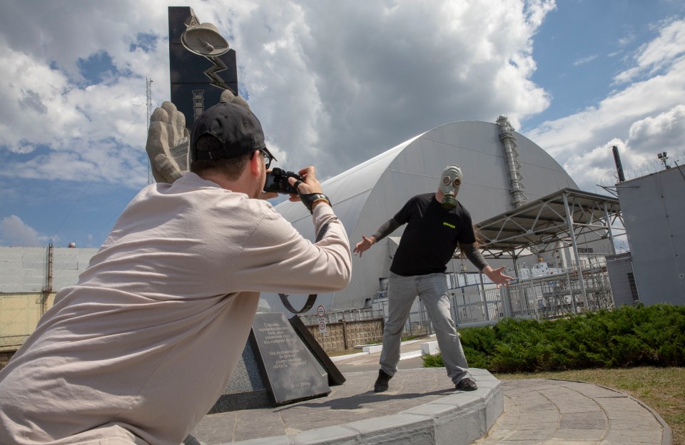  Eager tourists pose for pics in front of the new protective shield