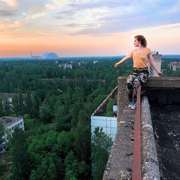 This infuencer overlooks the overgrowth while posing up high at what appears to be Chernobyl