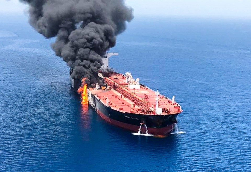 Huge plumes of thick black smoke billow from the massive tanker in the Gulf of Oman following a suspected torpedo attack