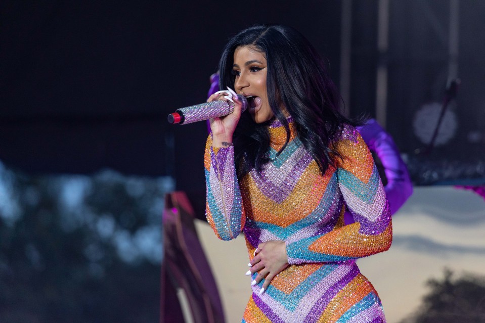 Cardi stunned in a figure hugging multicoloured catsuit on stage