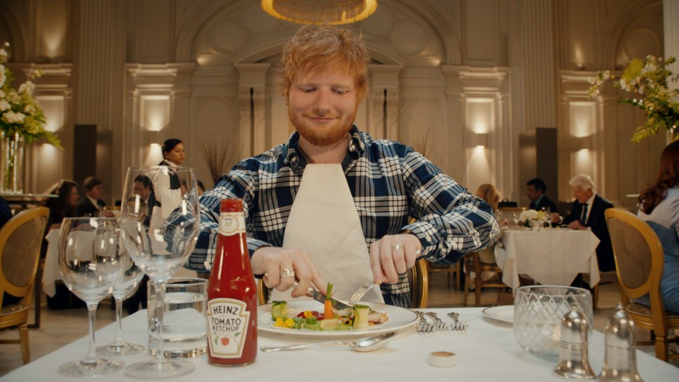 Ed then enjoys his ketchup-covered meal with the famous Heinz bottle visible on the table