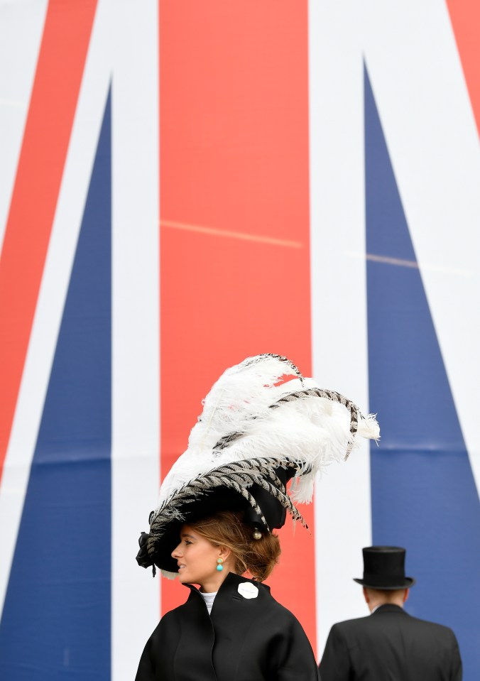 One racegoer wears a black-feathered hat with teal drop earrings