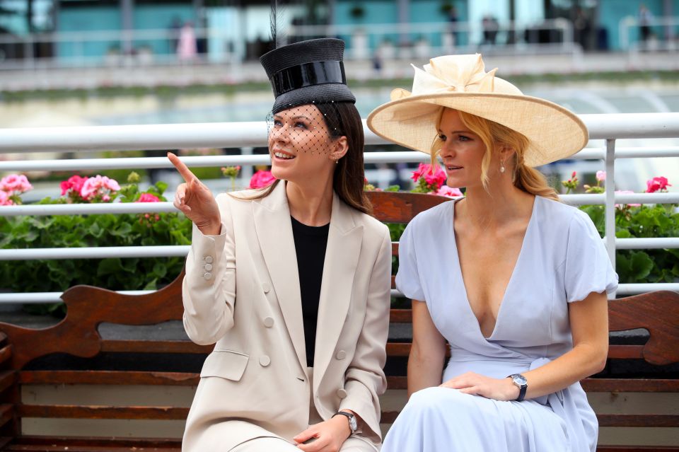 Two racegoers sit as punters head into the grounds