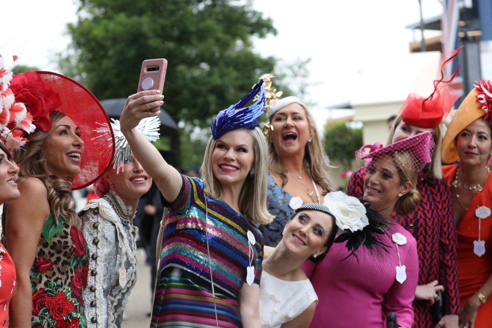 Racegoers in vibrant hats and dressed take a selfie on the first day of the Royal Ascot