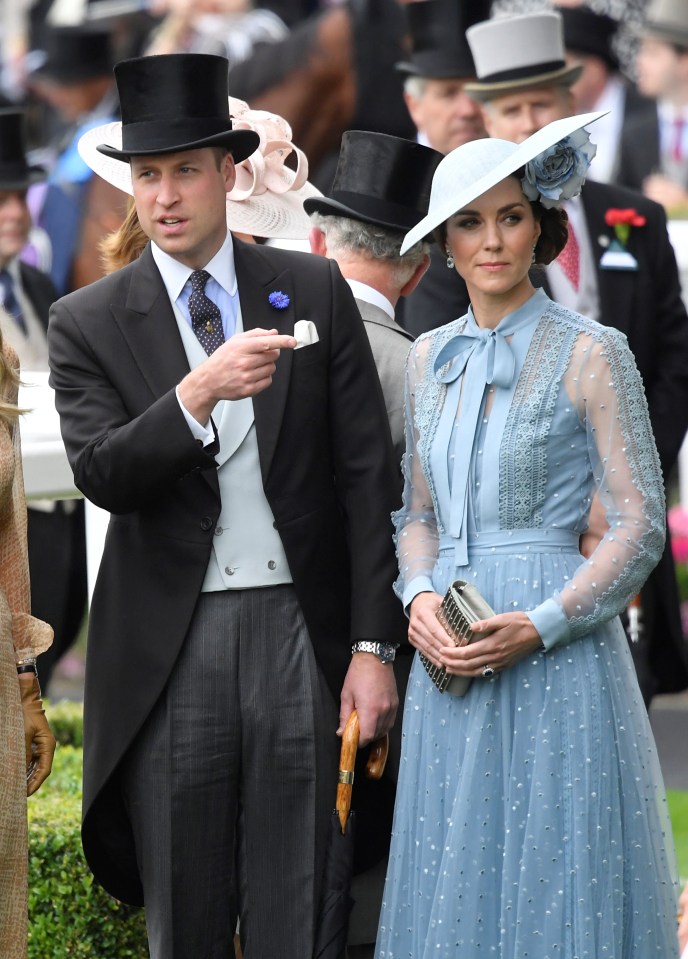 Prince William makes a pointing gesture while wearing a traditional top hat