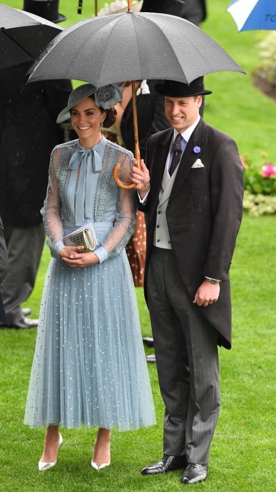 Prince William holds an umbrella over himself and Kate as it drizzles at the Royal Ascot