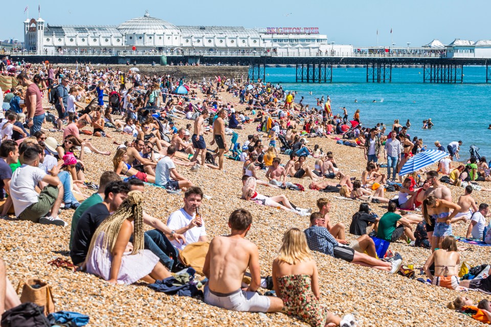 Crowds enjoy the sunny weather by spending time on the beach and Palace Pier in Brighton and Hove