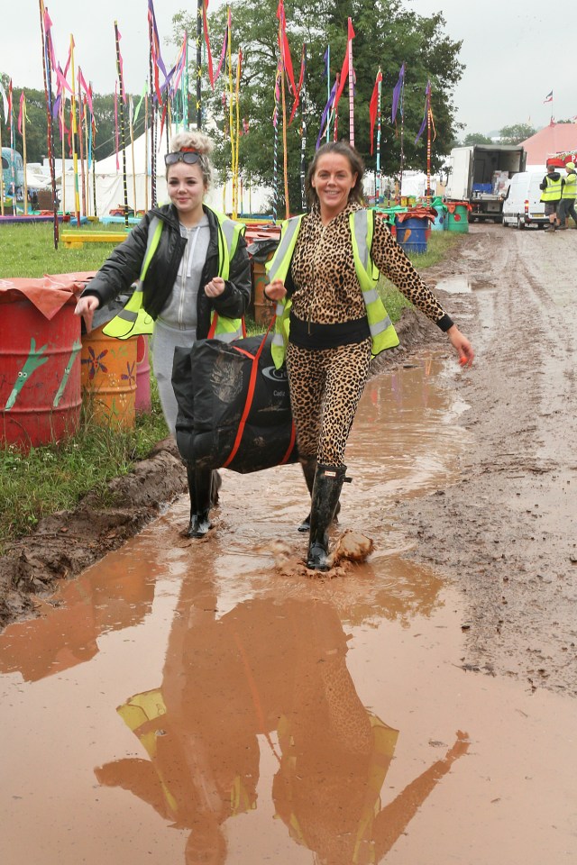 Glastonbury festival-goers run through the mud in their wellies after heavy rain overnight