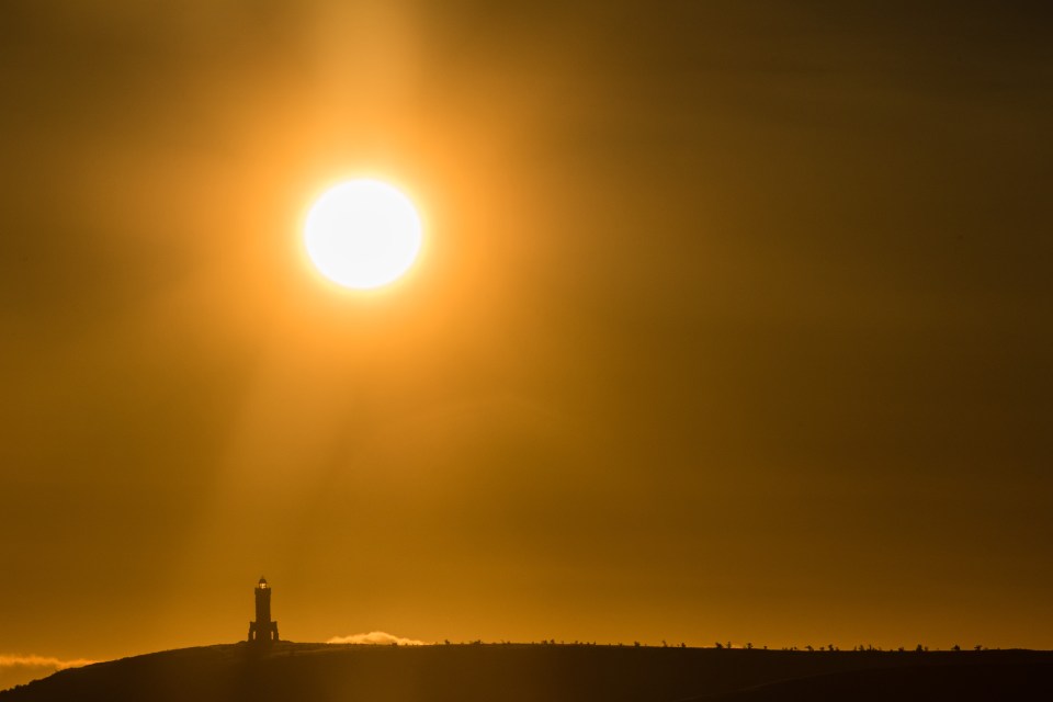 The sun rises behind the Darwen Jubilee Tower in Rivington, Lancs.