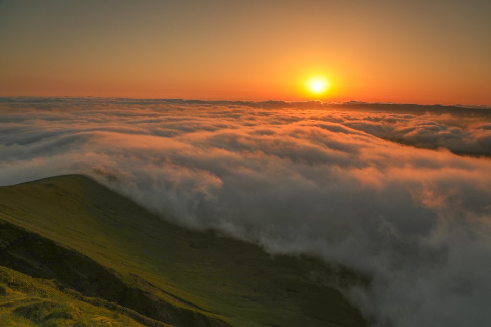 Dramatic sunrise over the Brecon Beacons with temperature inversion creating clouds at low level