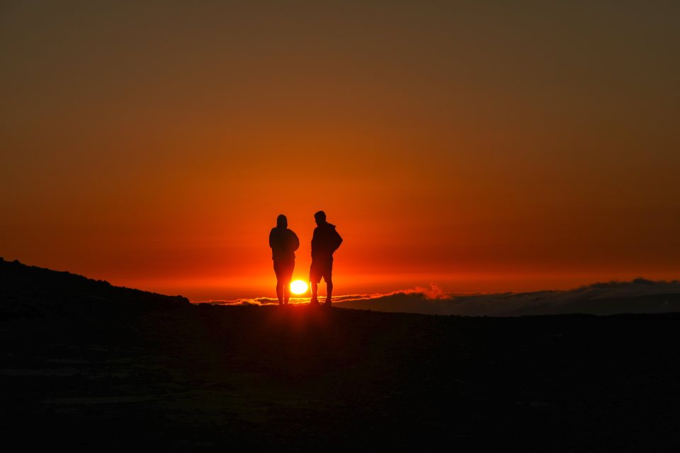 Two hikers get an early start to catch the sunrise over Brecon Beacons in Wales