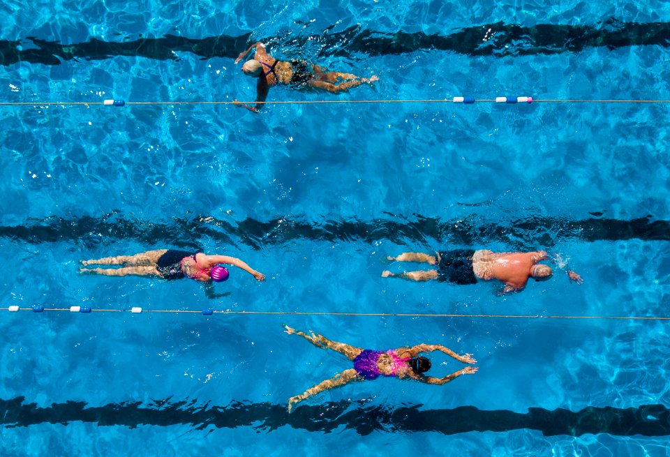 Swimmers in basking on the sunshine while getting their morning swim in