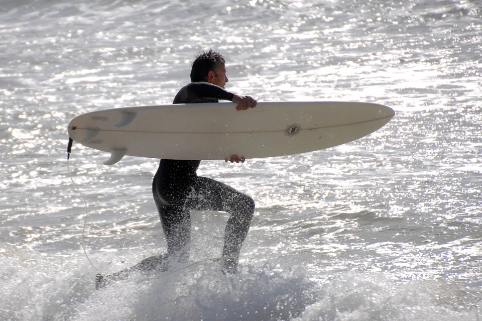 A surfer h its the waves this morning at Preston Beach in Weymouth