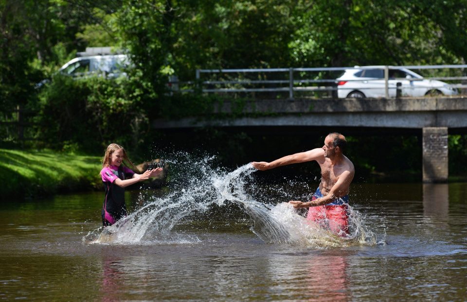 Shawn Wickett and his daughter Emily, 12, cool off with a water fight this morning in Lymington River near Balmer Lawn Hotel in the New Forest, Hants