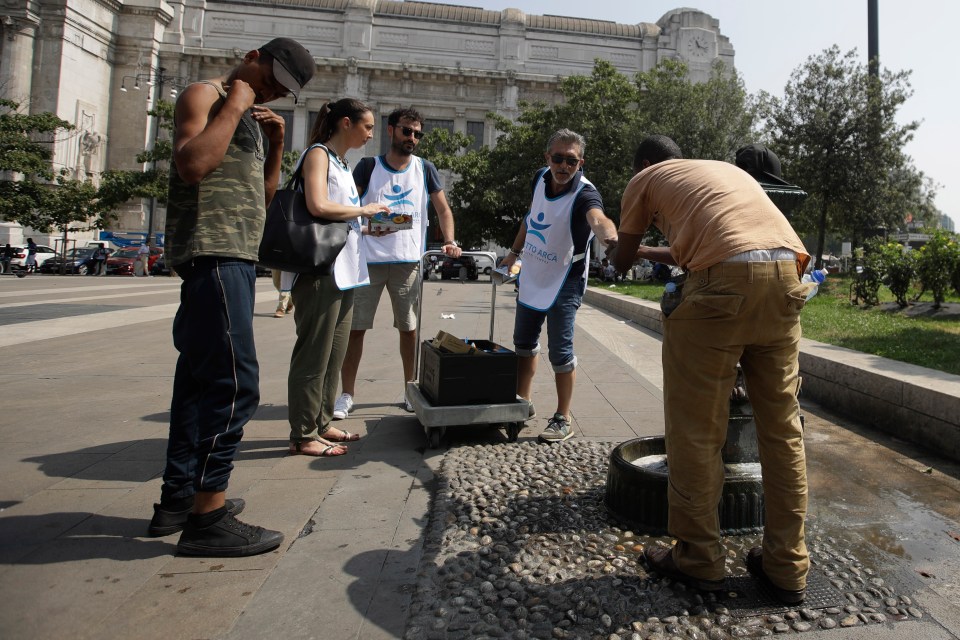  Volunteers distribute free bottles of water outside Milan's central railway station