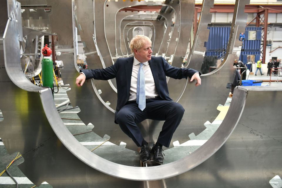  Boris sits on a boat during a visit to the Isle of Wight wearing a fresh pair of plain black socks