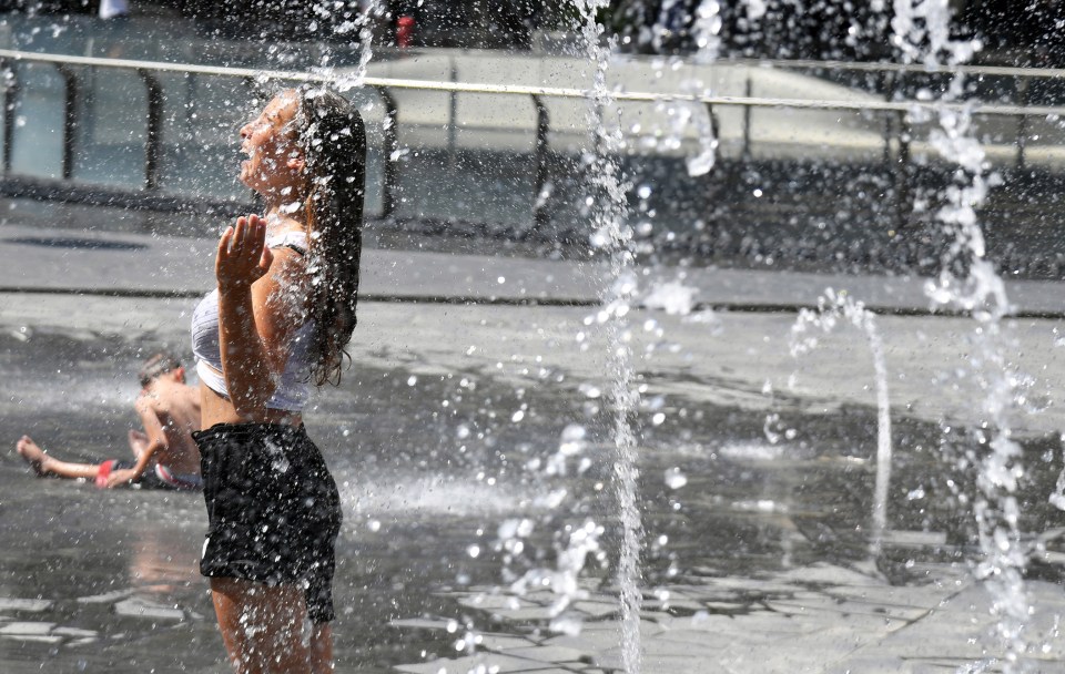  A girl cools off as water sprinkles from a fountain in central Gai Aulenti square in Milan, Italy, as the Sahara Bubble comes to the boil