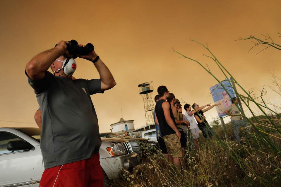  Residents gather as a forest fire rages near Maials in the northeastern region of Catalonia