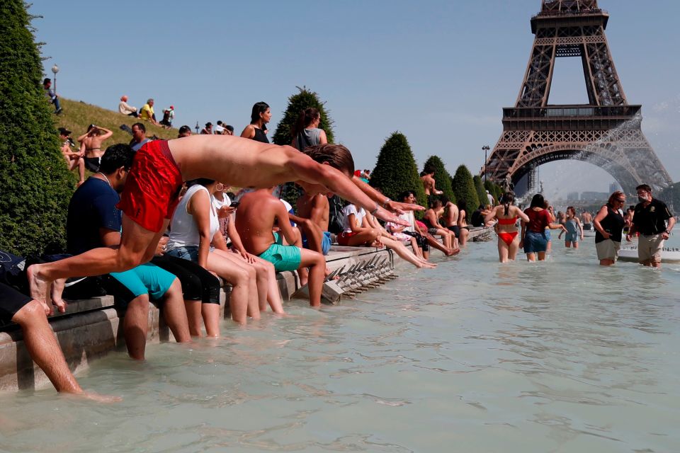  A boy jumps into the water of the Trocadero Fountain in Paris during the heatwave on June 28