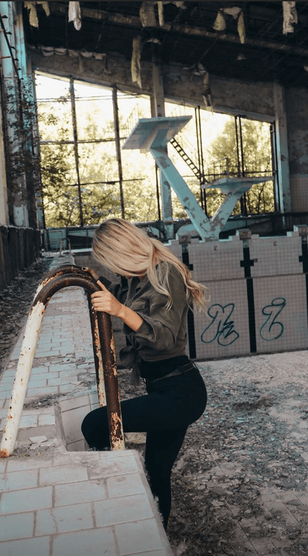  One woman poses as she steps into the abandoned swimming pool on the Chernobyl site