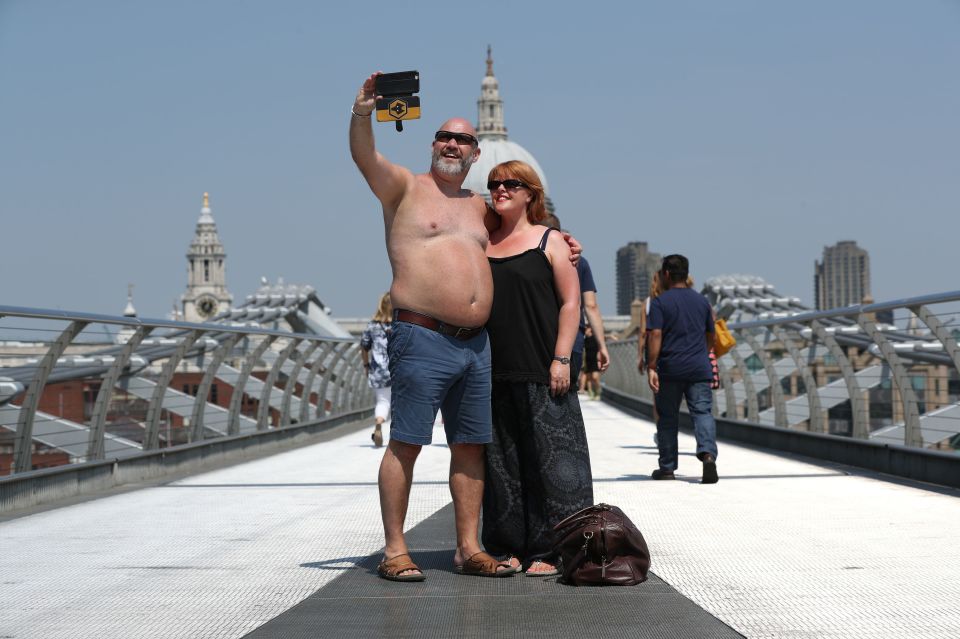  A couple pose for a snap on the London Millennium Bridge during a recent heatwave