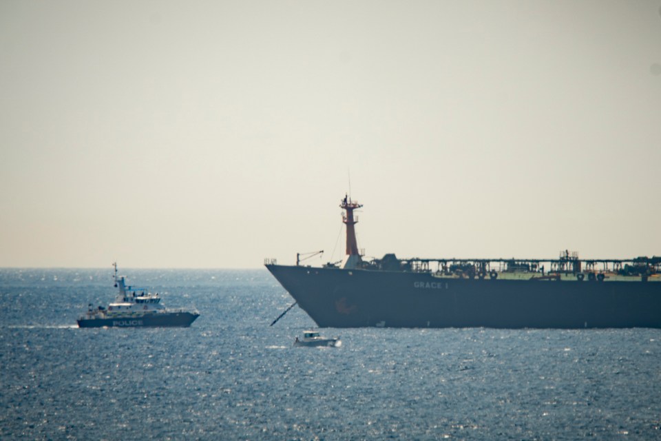  A police boat is seen moored next to the giant vessel