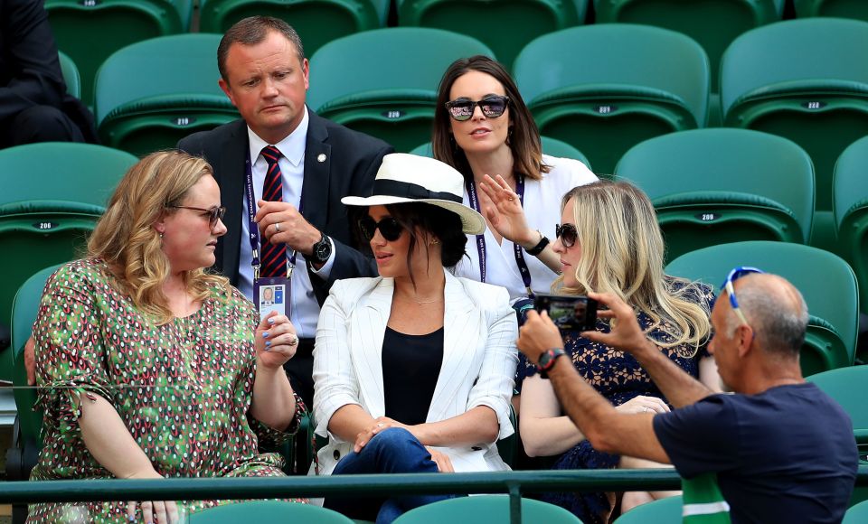  A spectator takes a photo in front of the Duchess of Sussex at Wimbledon last week