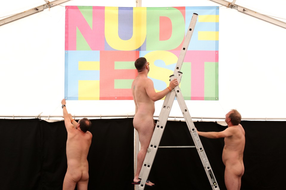  Festival-goers come together to put up the annual Nudefest sign