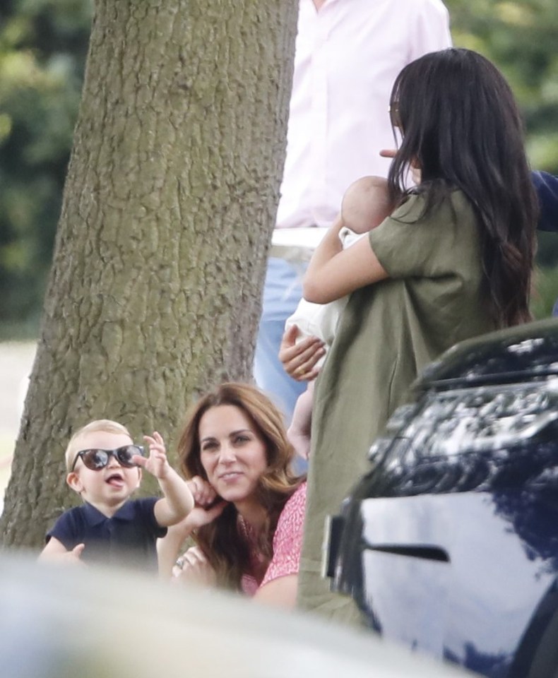 Prince Louis pulls a face as he sits with his mum Kate and aunt Meghan and cousin Archie