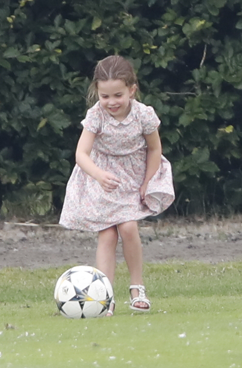 Princess Charlotte plays with a football as her dad plays polo