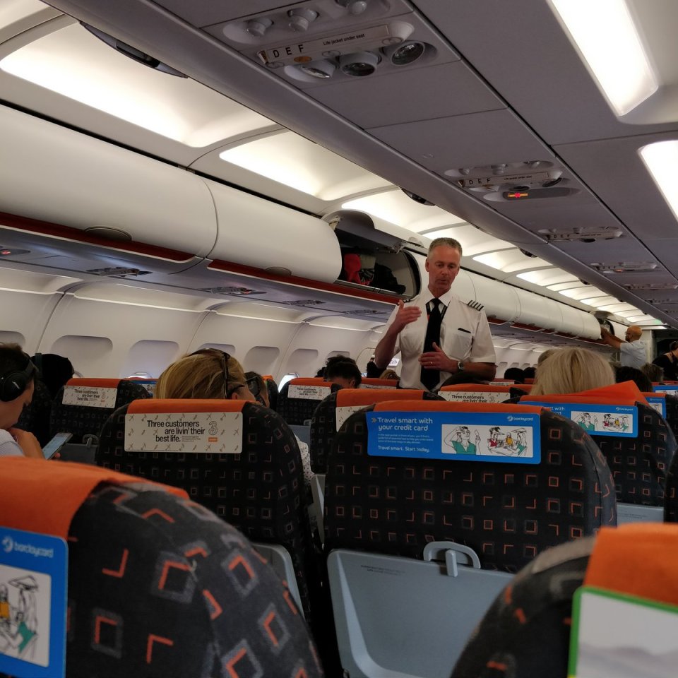 This image show a pilot explaining to passengers what is happening at Gatwick Airport