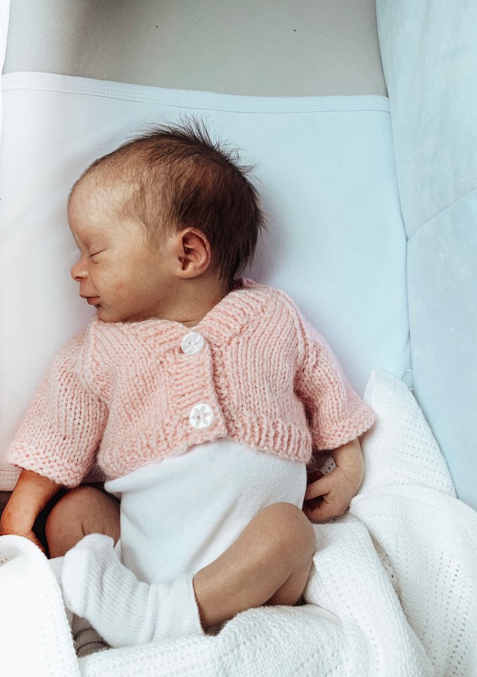  She wears an adorable pink knitted cardigan in her first official photos