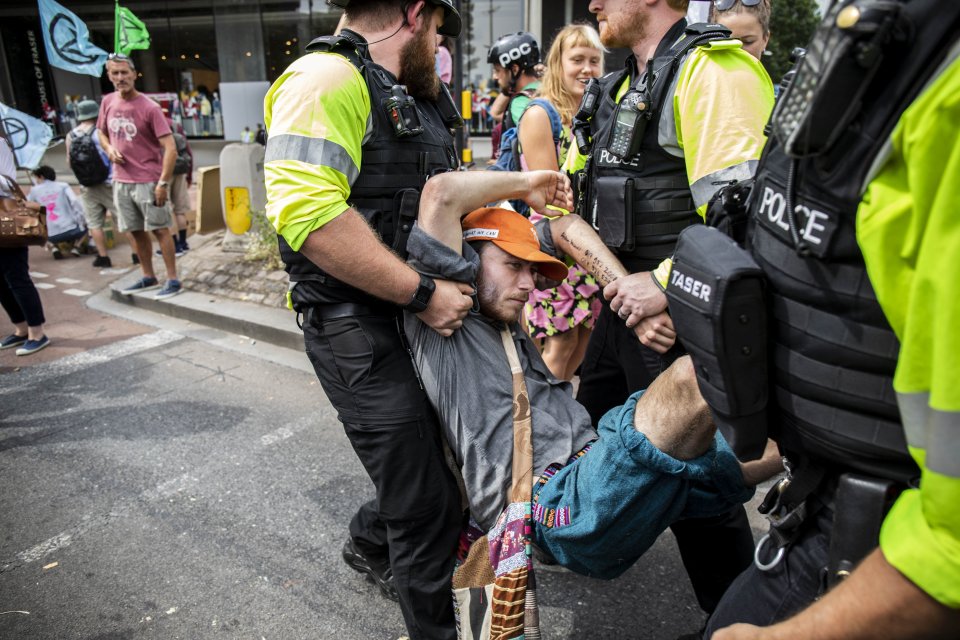 A protester is carried away after Extinction Rebellion protesters block the M32, a main route into the city centre resulting in queues of around 4 miles long