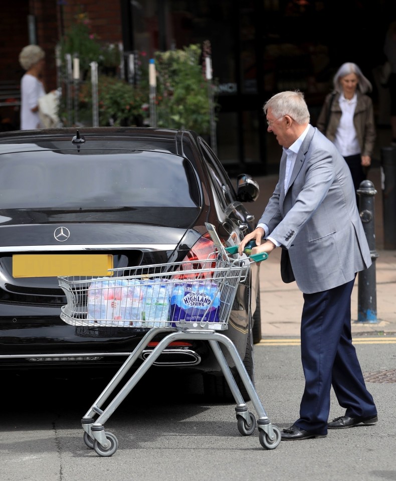  Sir Alex Ferguson pushes a trolley load of bottles of water