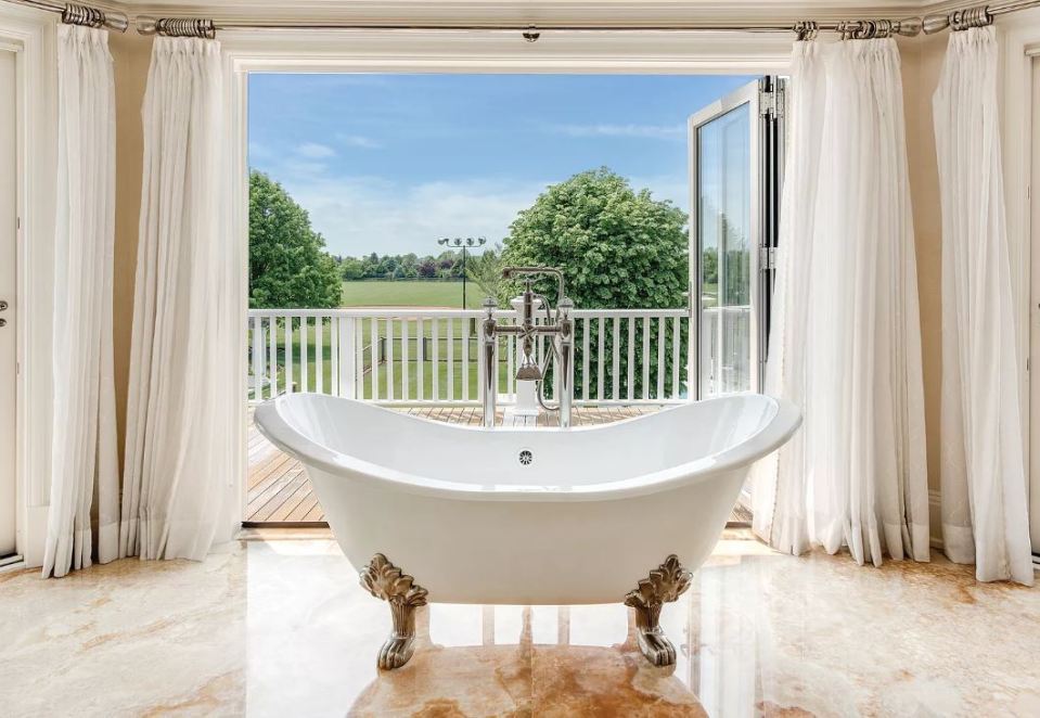  The indulgent master bath is surrounded by honey onyx slabs, and an expansive terrace with an outdoor shower