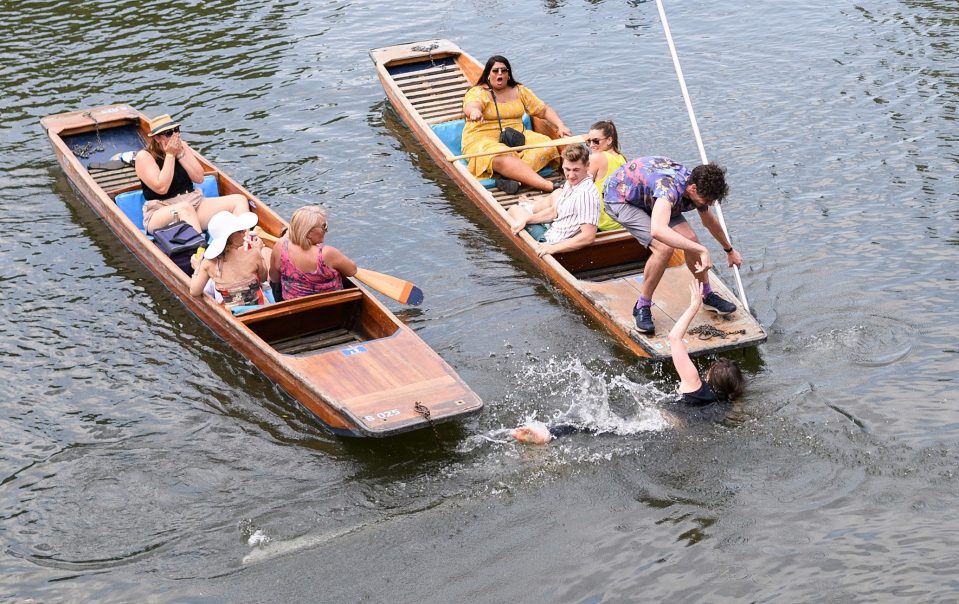  A woman is helped out of the River Cam in Cambridge as Brits sweltered on the UK's hottest day ever