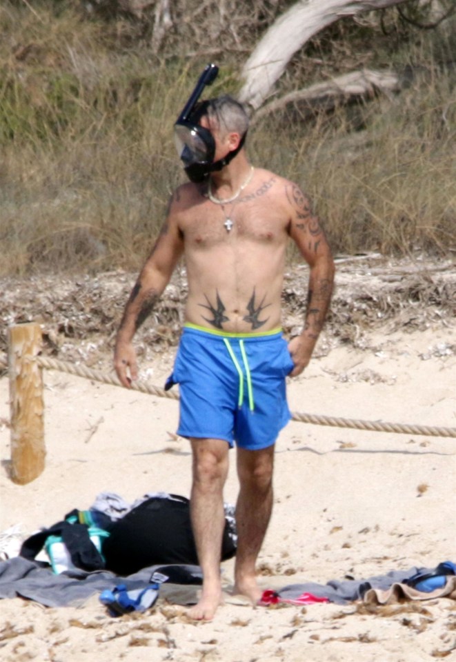  The singer paraded his inked body around the beach and put on his snorkel