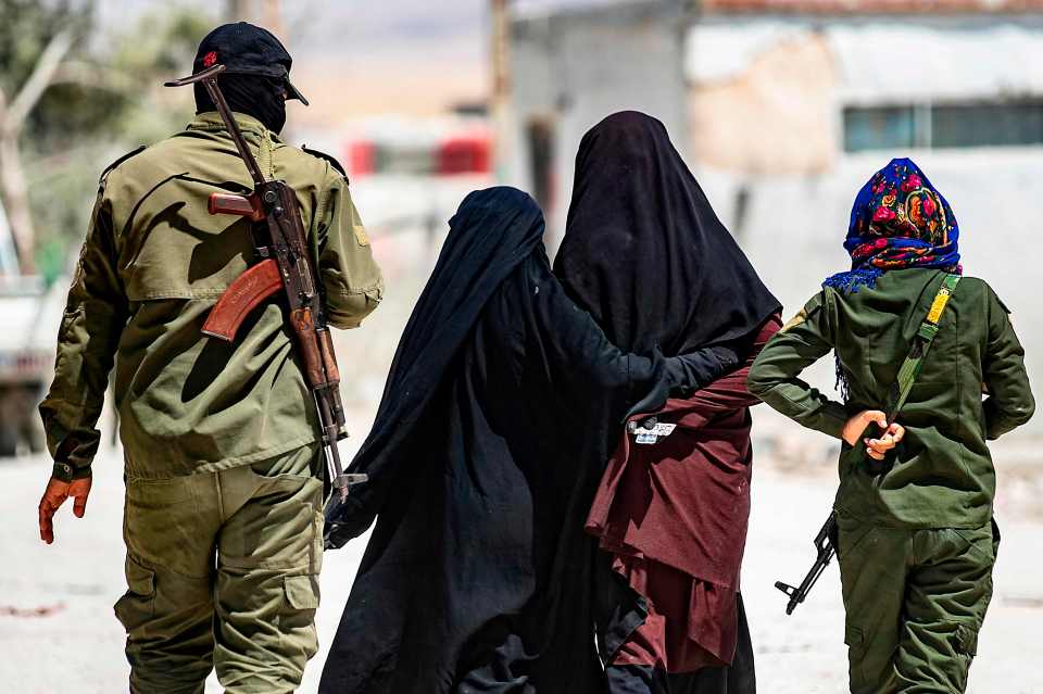  Security patrols escort women, reportedly wives of ISIS fighters, in the al-Hawl camp in northeastern Syria, July 23