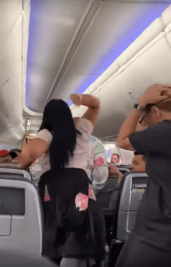 A woman was videoed flying into a rage and battering her boyfriend on board a plane