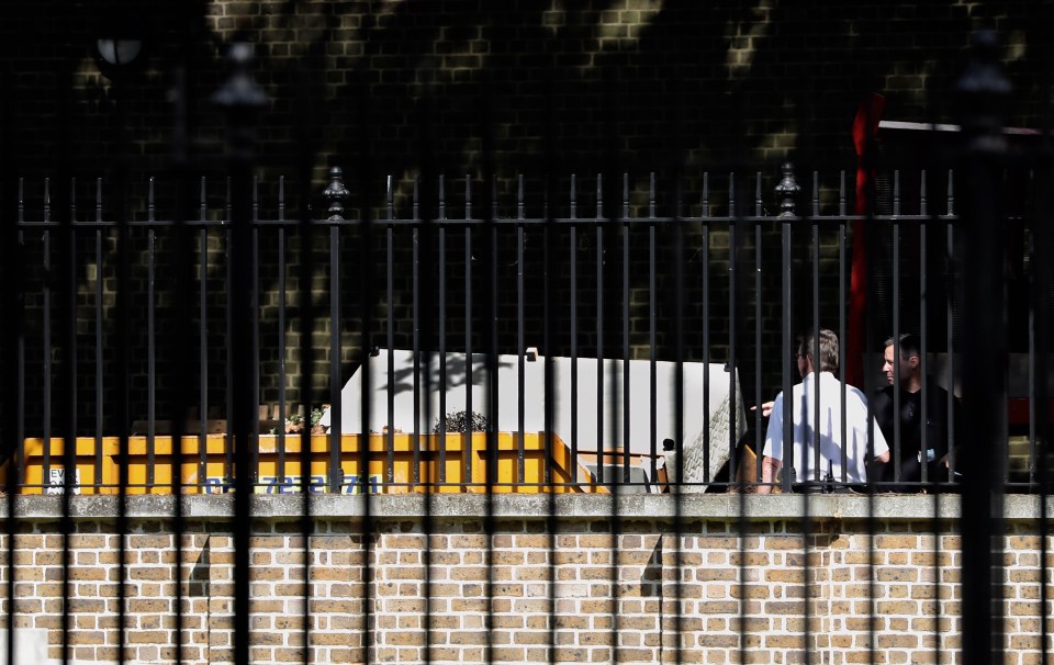  Workmen chuck out an old Divan double bed into the skip at the back of Downing Street today