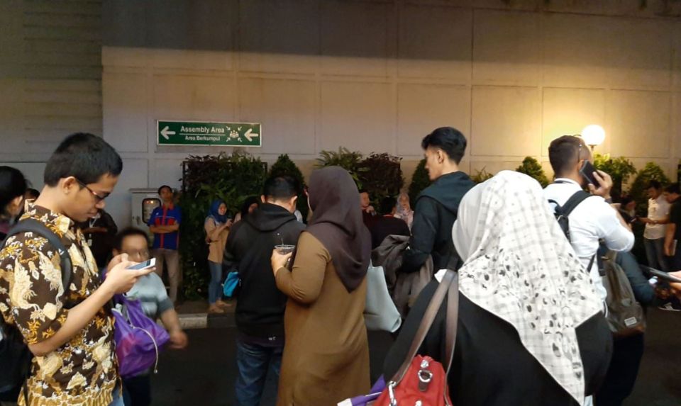  Employees of an office building stand outside after evacuating following a strong earthquake in the area in Serpong, Banten province, on August 2, 2019