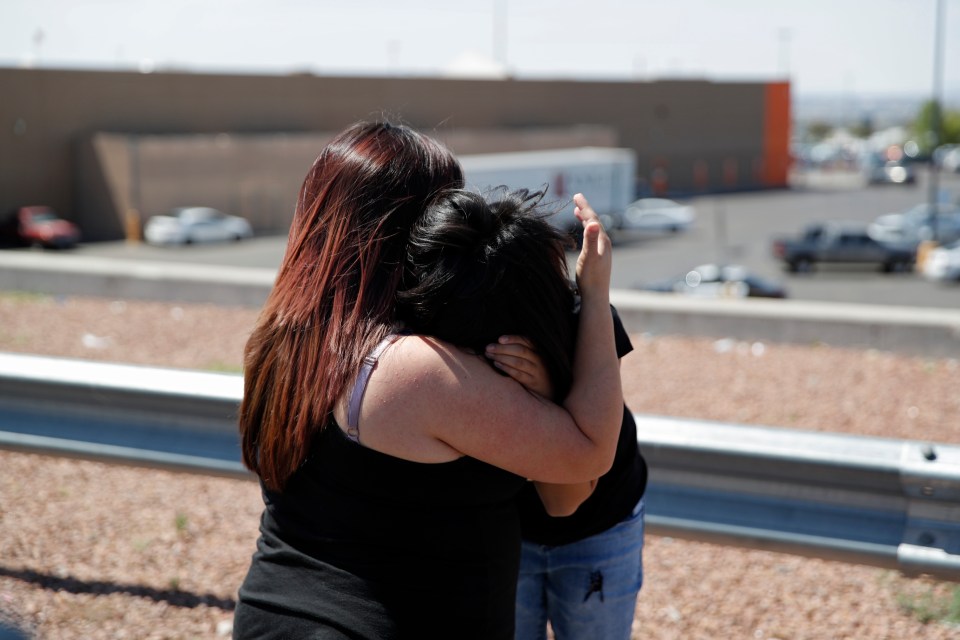  Two people console each other near the scene of the El Paso massacre