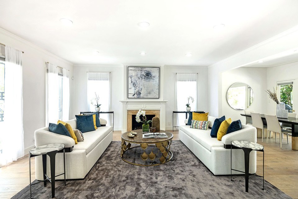 The spacious open-plan living room has a statement fireplace