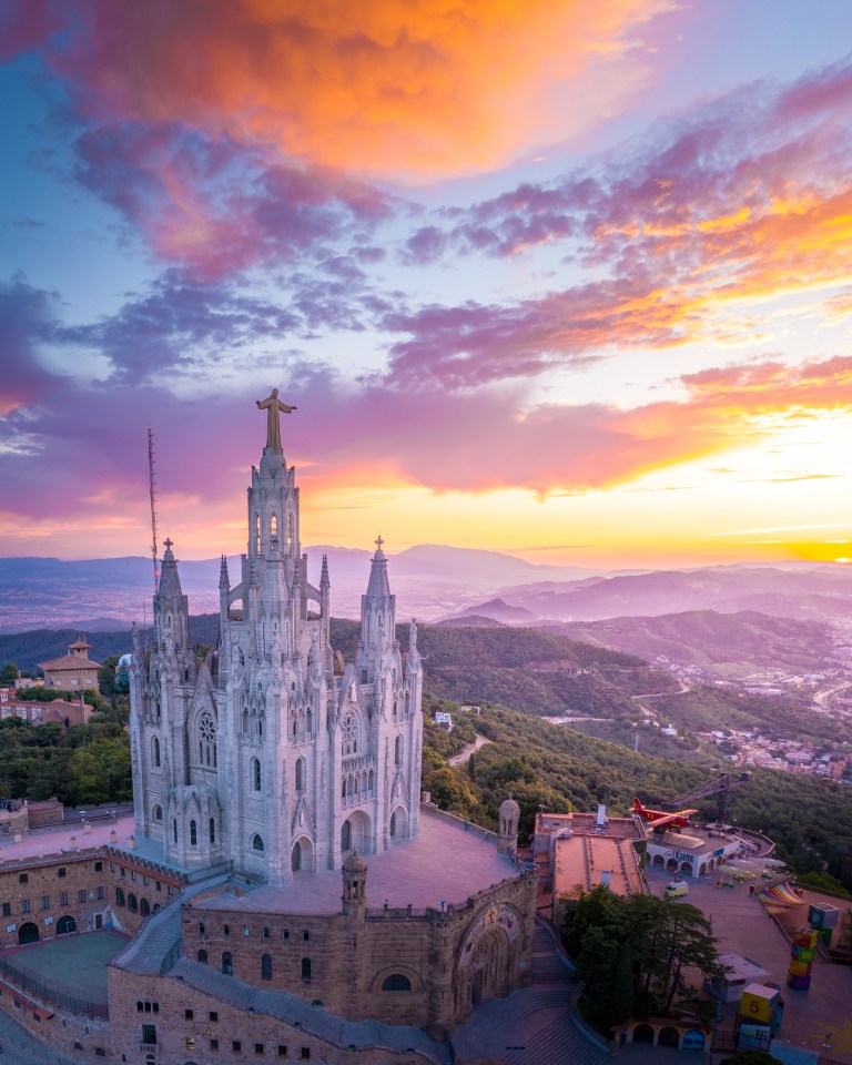  The dramatic skyline contrasts with a church overlooking Barcelona