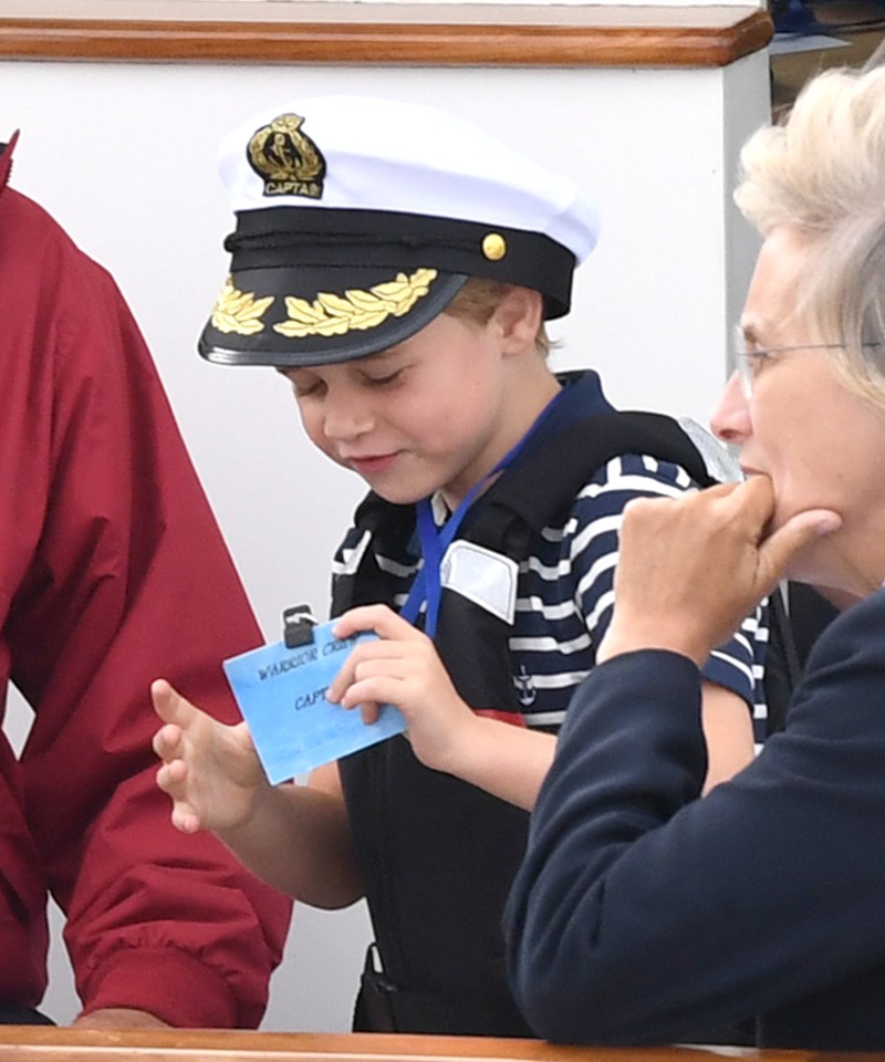 Prince George grins as he holds a 'Captain' nametag